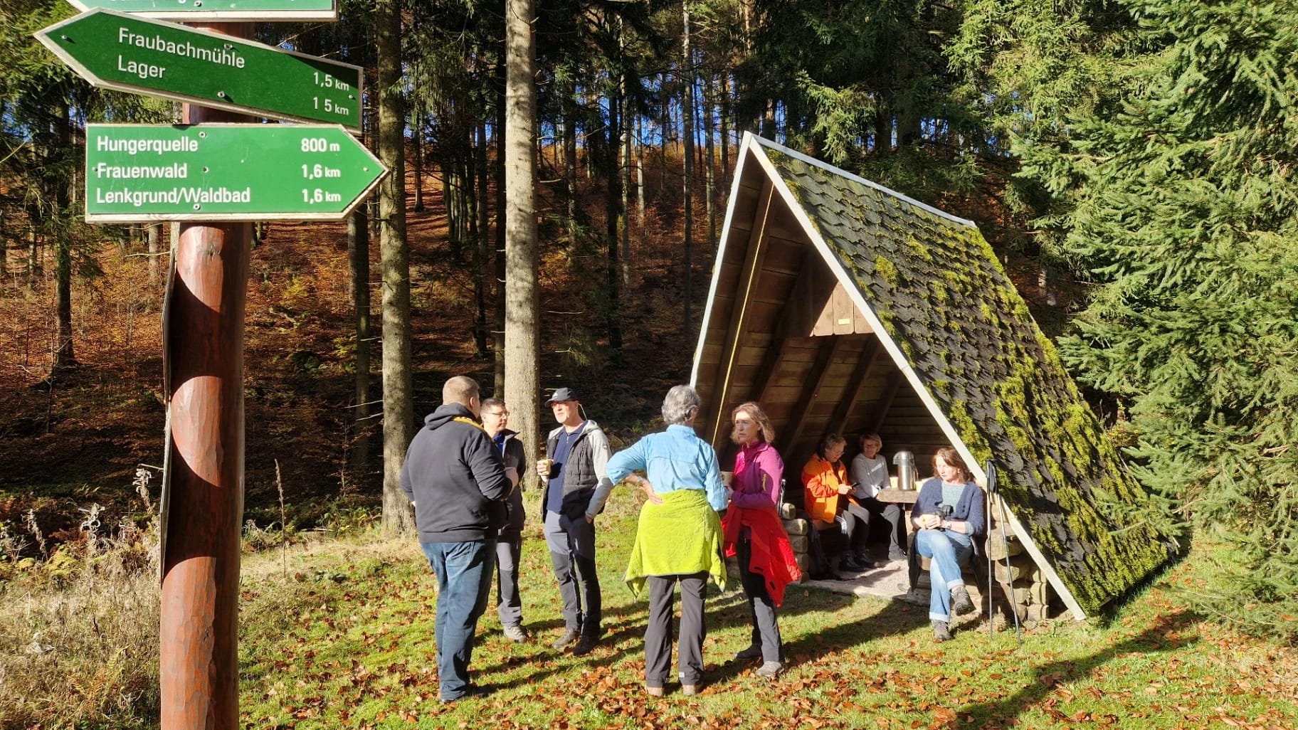 Wandergruppe an einer Schutzhütte im herbstlichen Thüringer Wald