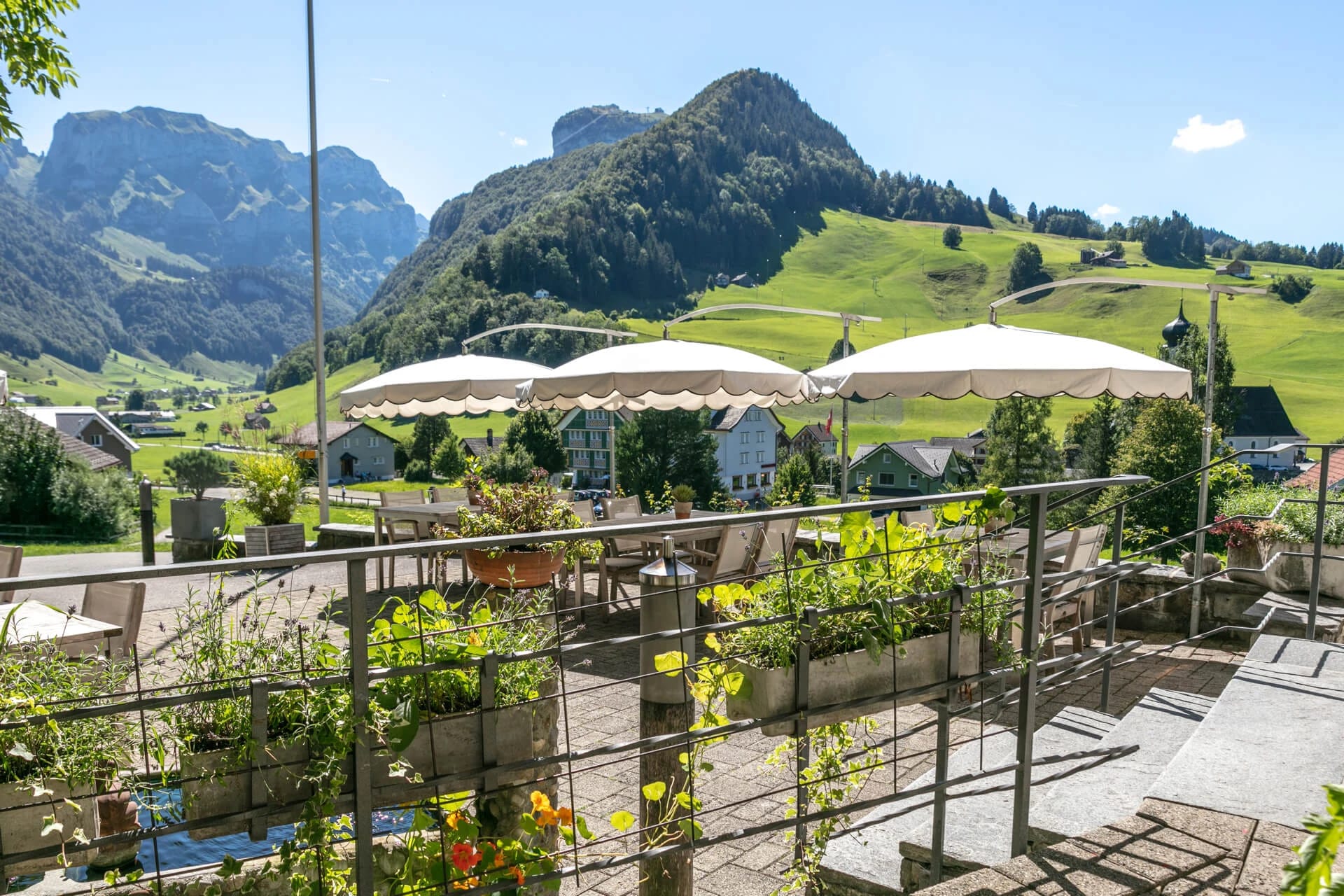 Terrasse mit Sonnenschirmen und Blick auf die Berge
