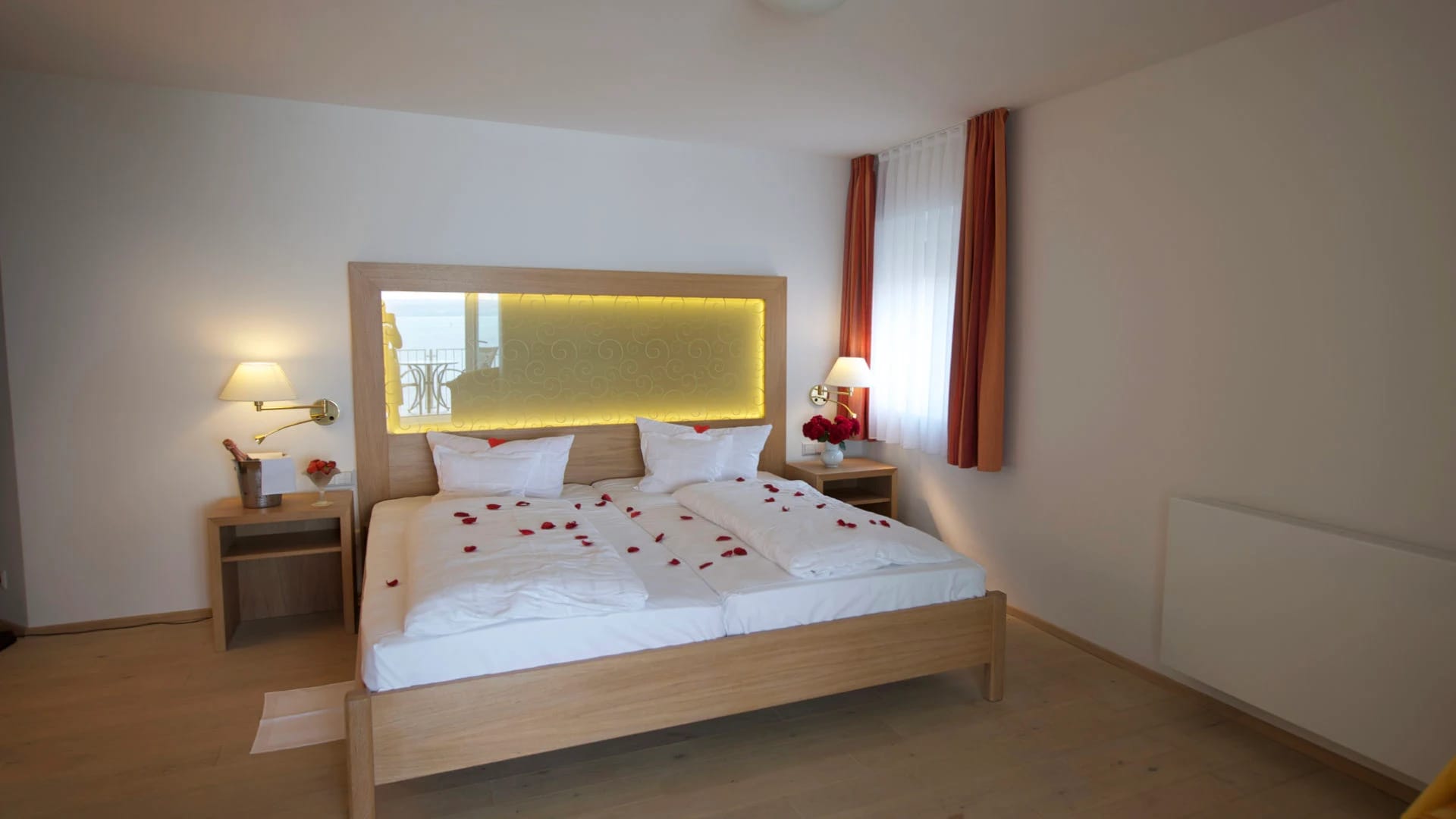 Doppelbett mit weißer Bettwäsche und beleuchtetem Kopfteil