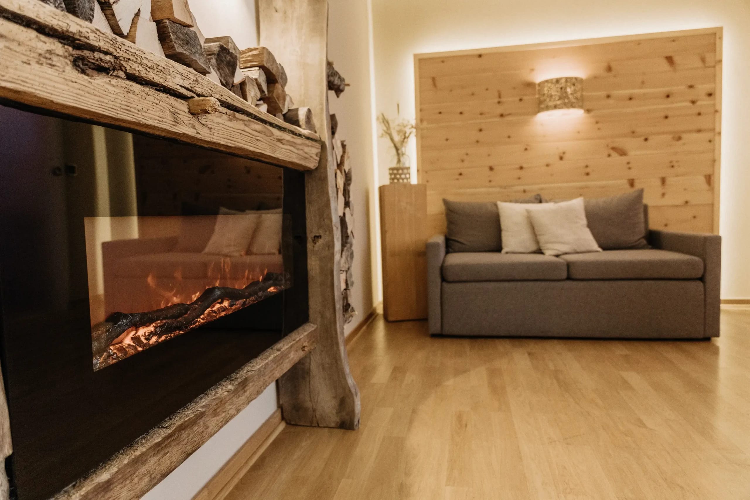 Wohnbereich mit Kamin, Sofa und Holzvertäfelung