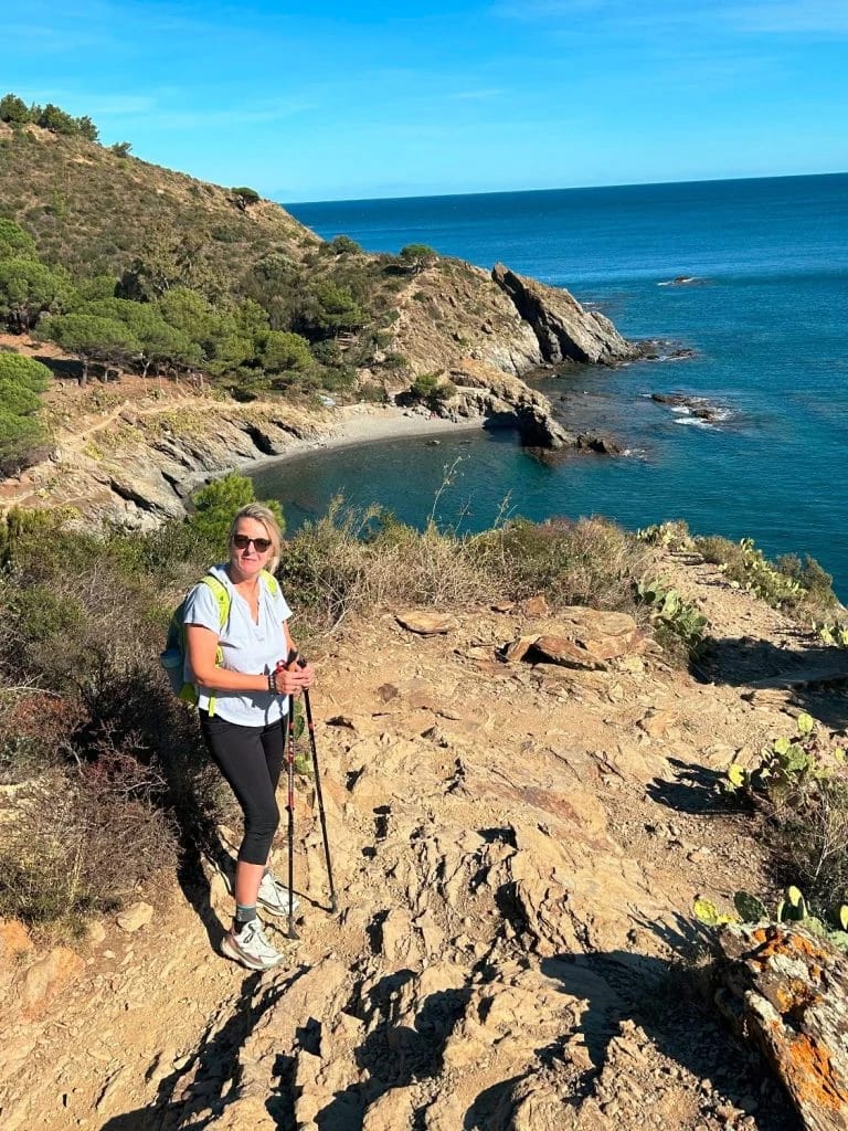 Anja Paulduro beim Wandern auf einem Küstenpfad mit Blick auf eine Bucht