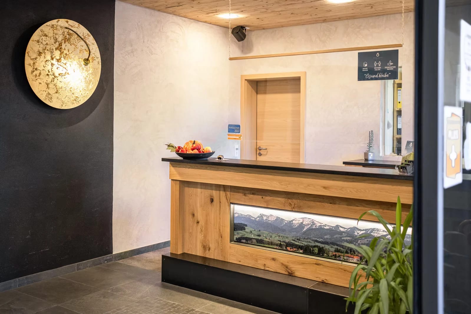 Hölzerner Rezeptionstresen mit Alpenpanorama-Motiv