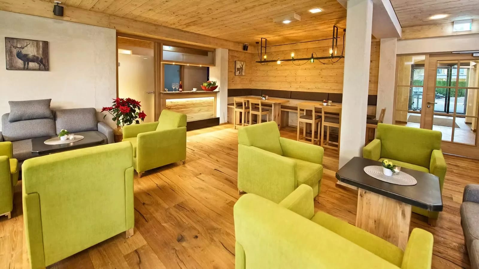 Lounge mit grünen Sesseln und Holzboden