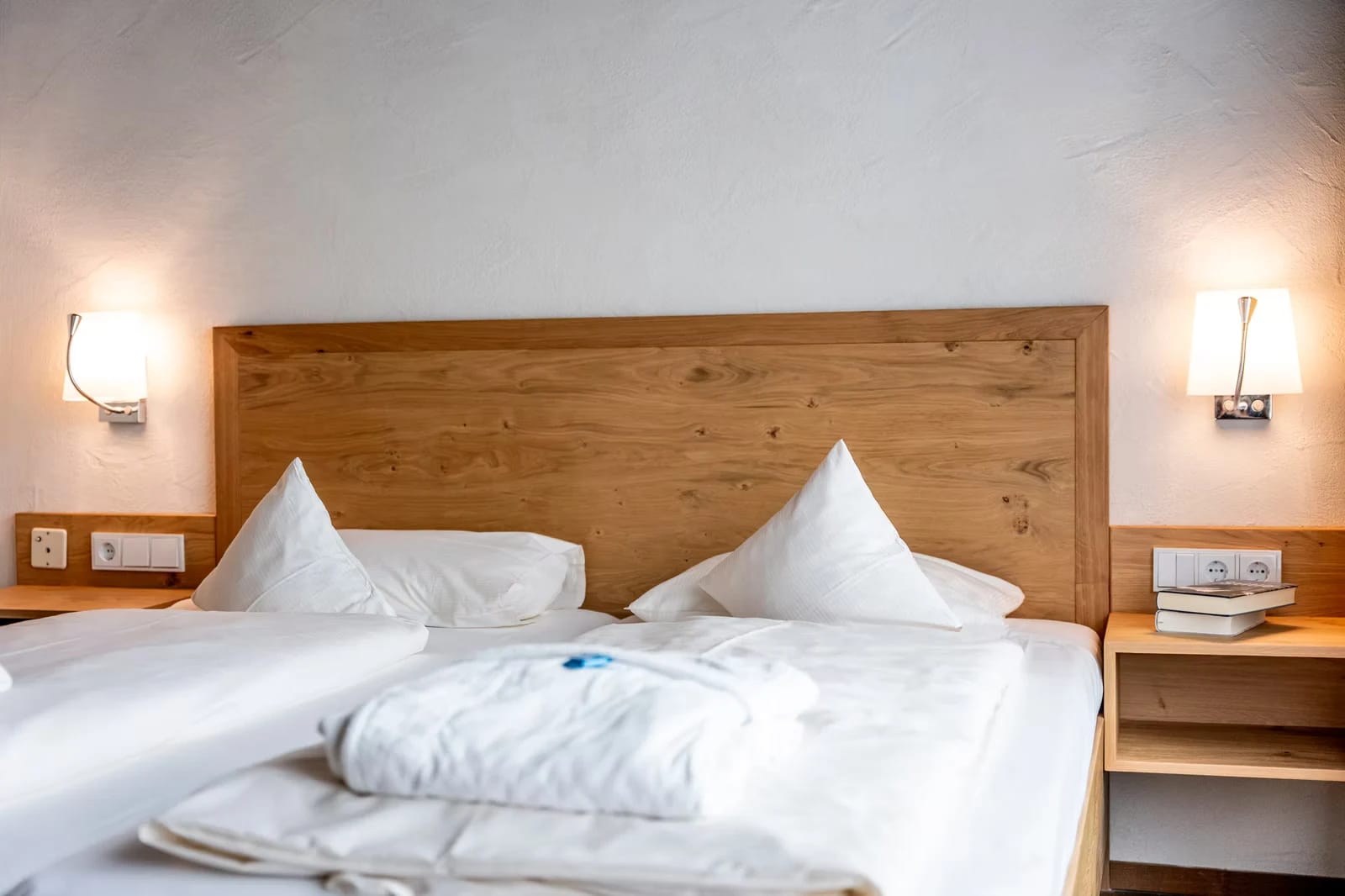 Doppelzimmer mit Holz-Kopfteil und weißer Bettwäsche