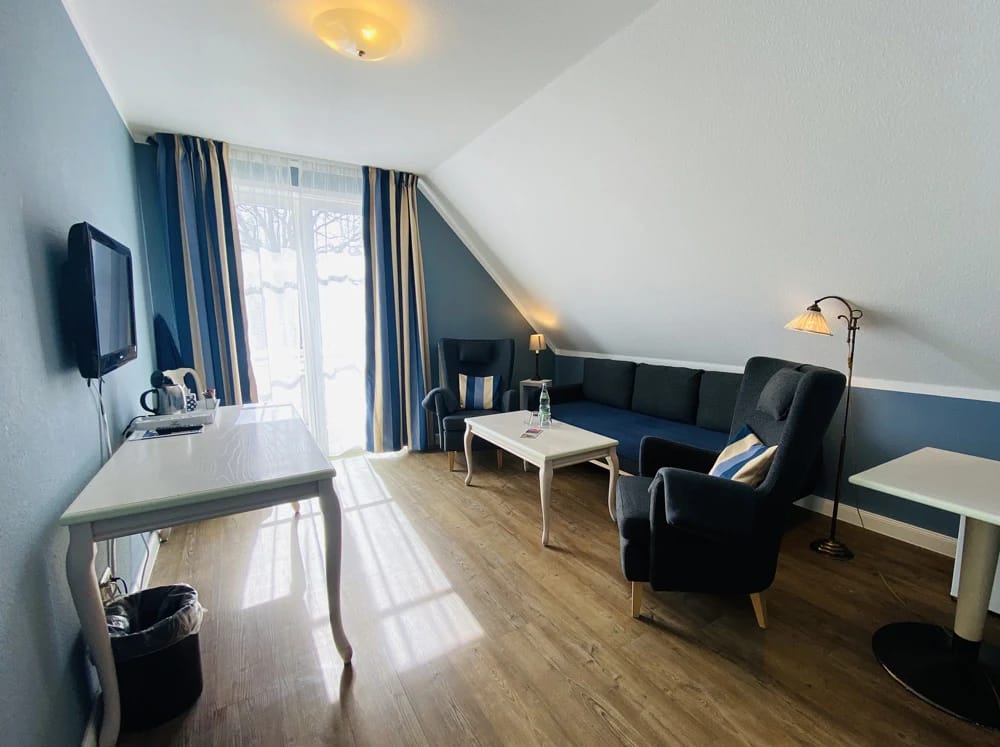 Wohnbereich einer Suite mit Sofa, Sessel und Schreibtisch