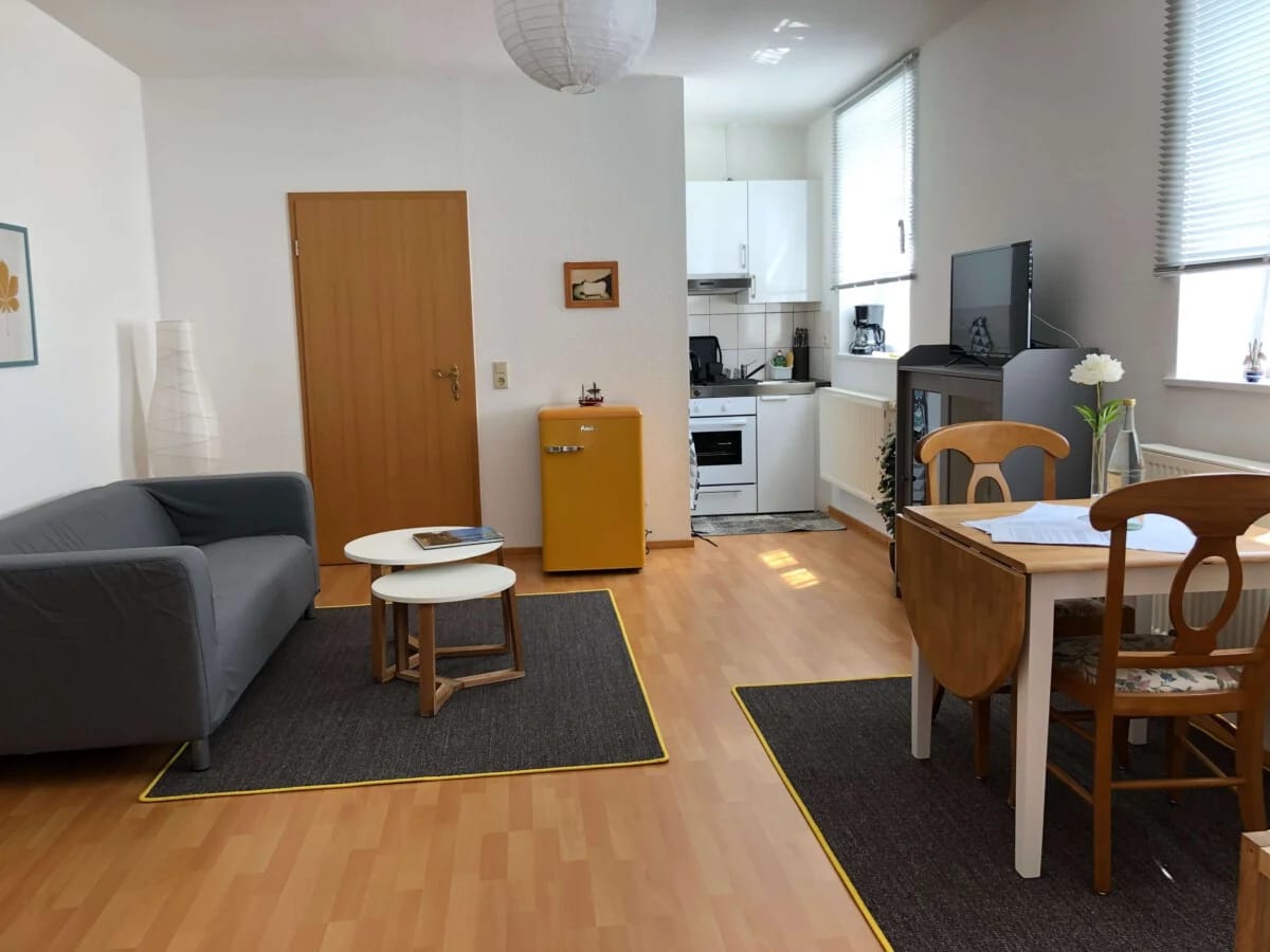 Offener Wohn- und Küchenbereich einer Ferienwohnung mit Sofa und Esstisch