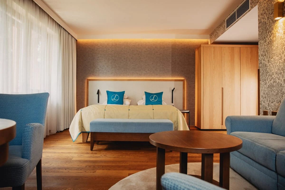 Zimmer mit Doppelbett, Sitzecke und blauen Sesseln