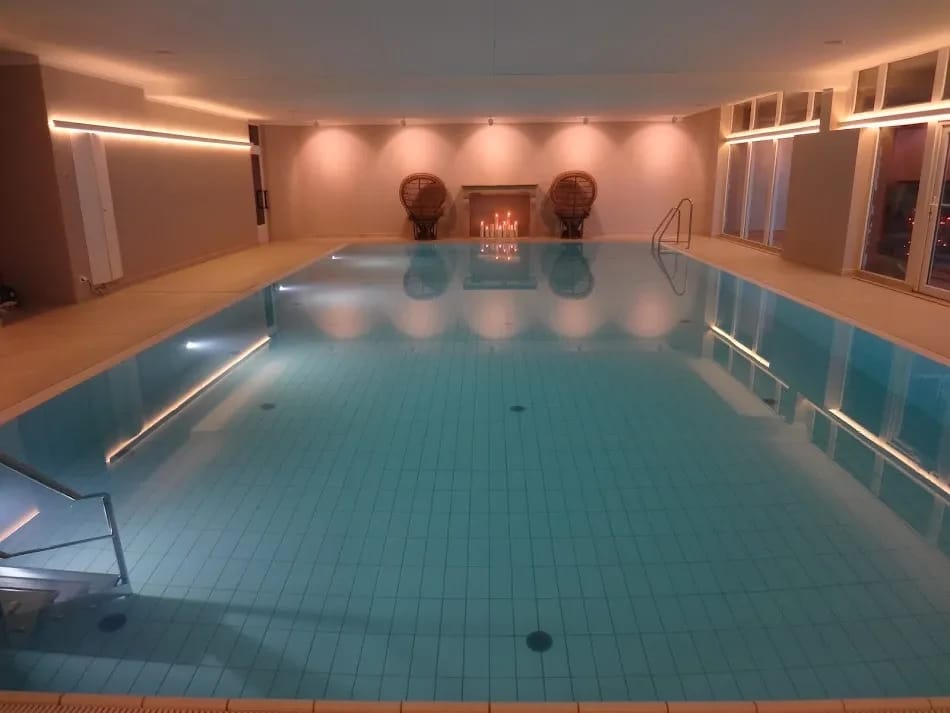Innenpool mit türkisem Wasser und warmer Beleuchtung