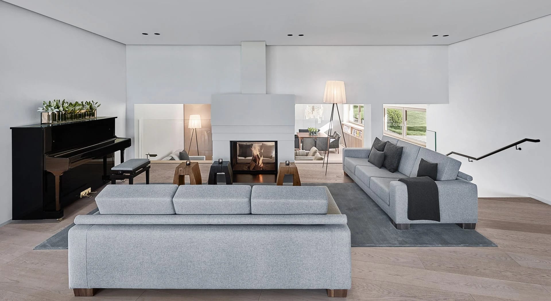 Lounge mit Sofas, Klavier und offenem Kamin