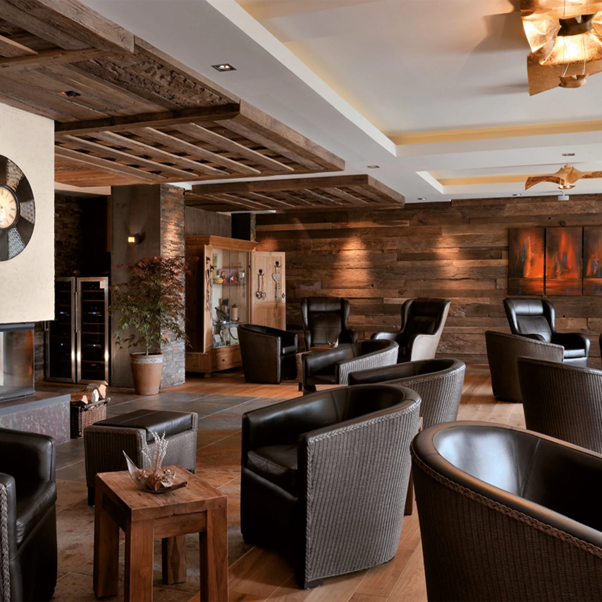 Lounge mit Sesseln, Holzwänden und warmer Beleuchtung