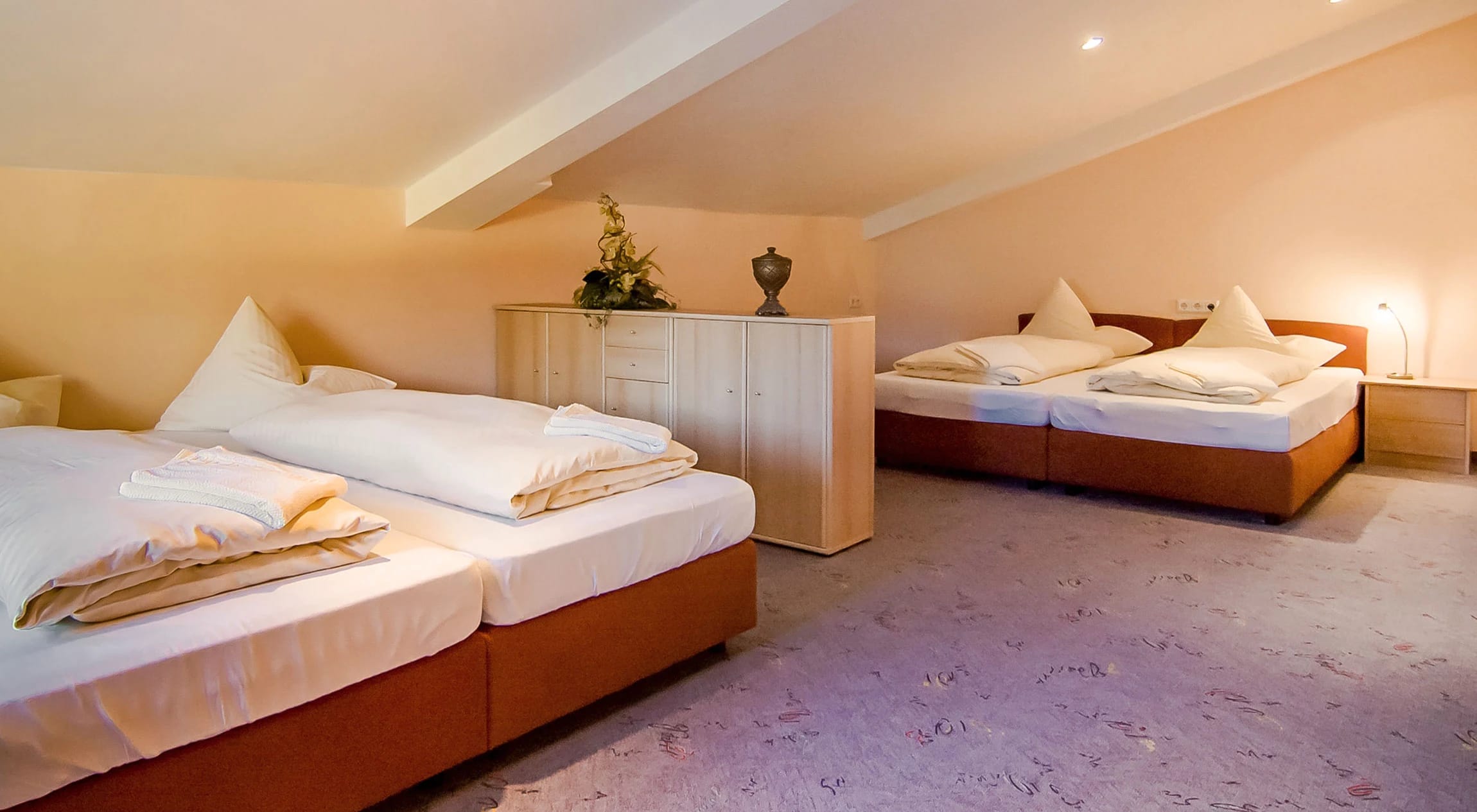 Appartement mit zwei Betten unter der Dachschräge und heller, warmer Einrichtung