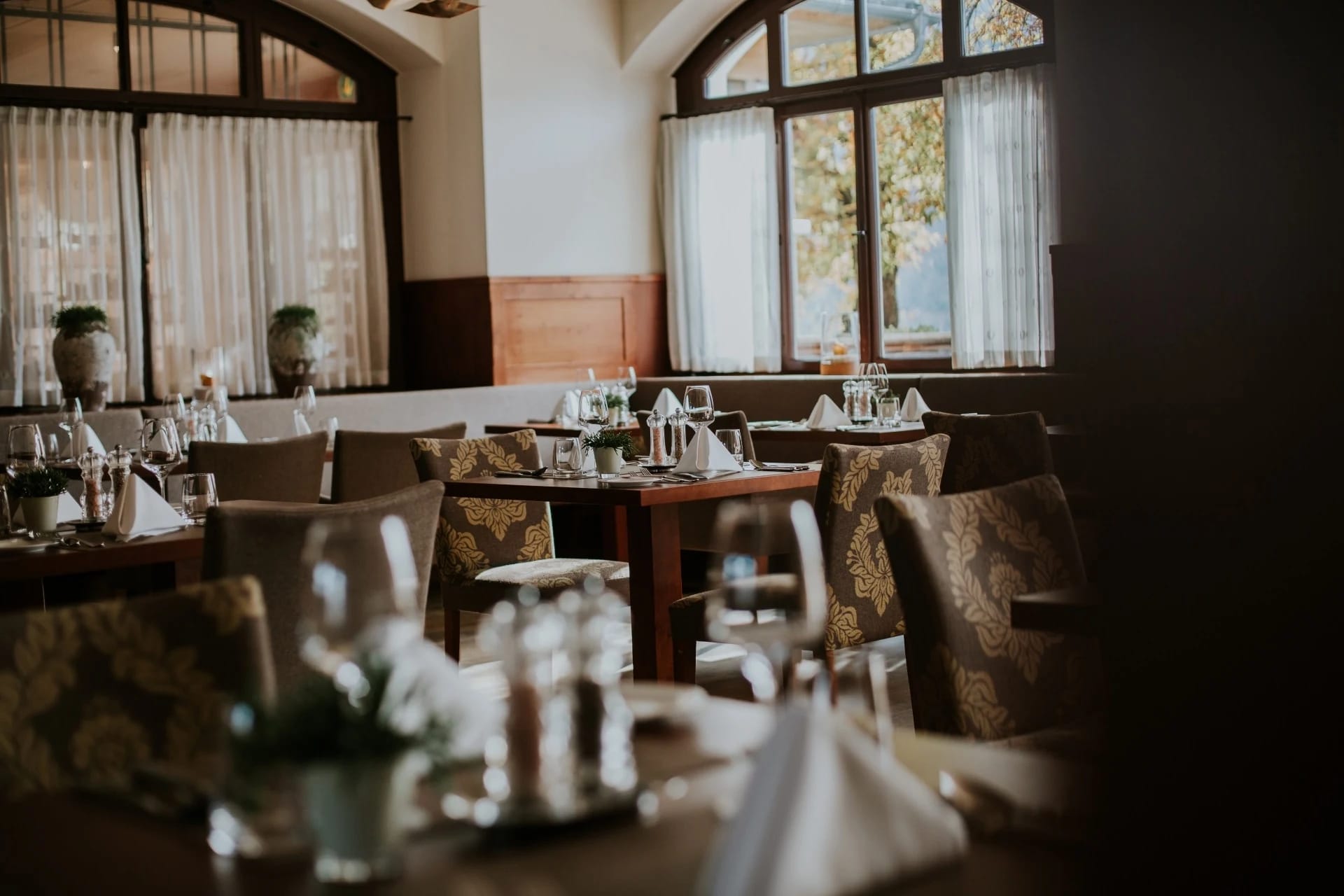 Klassischer Restauranthauptraum der Wasnerin mit dunklem Holz und eingedeckten Tischen