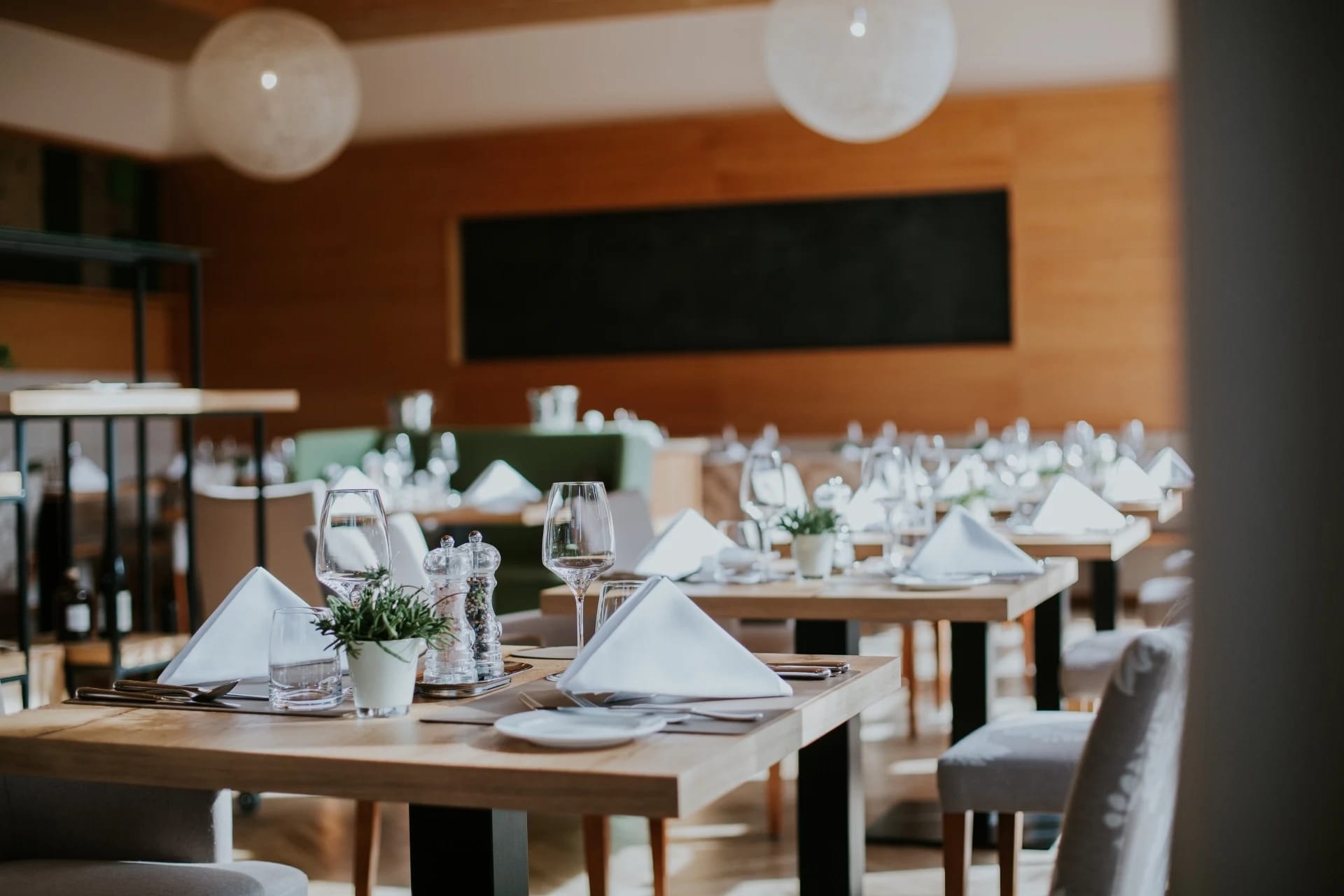 Moderner Restaurantbereich mit hellen Holztischen und eingedeckten Gedecken