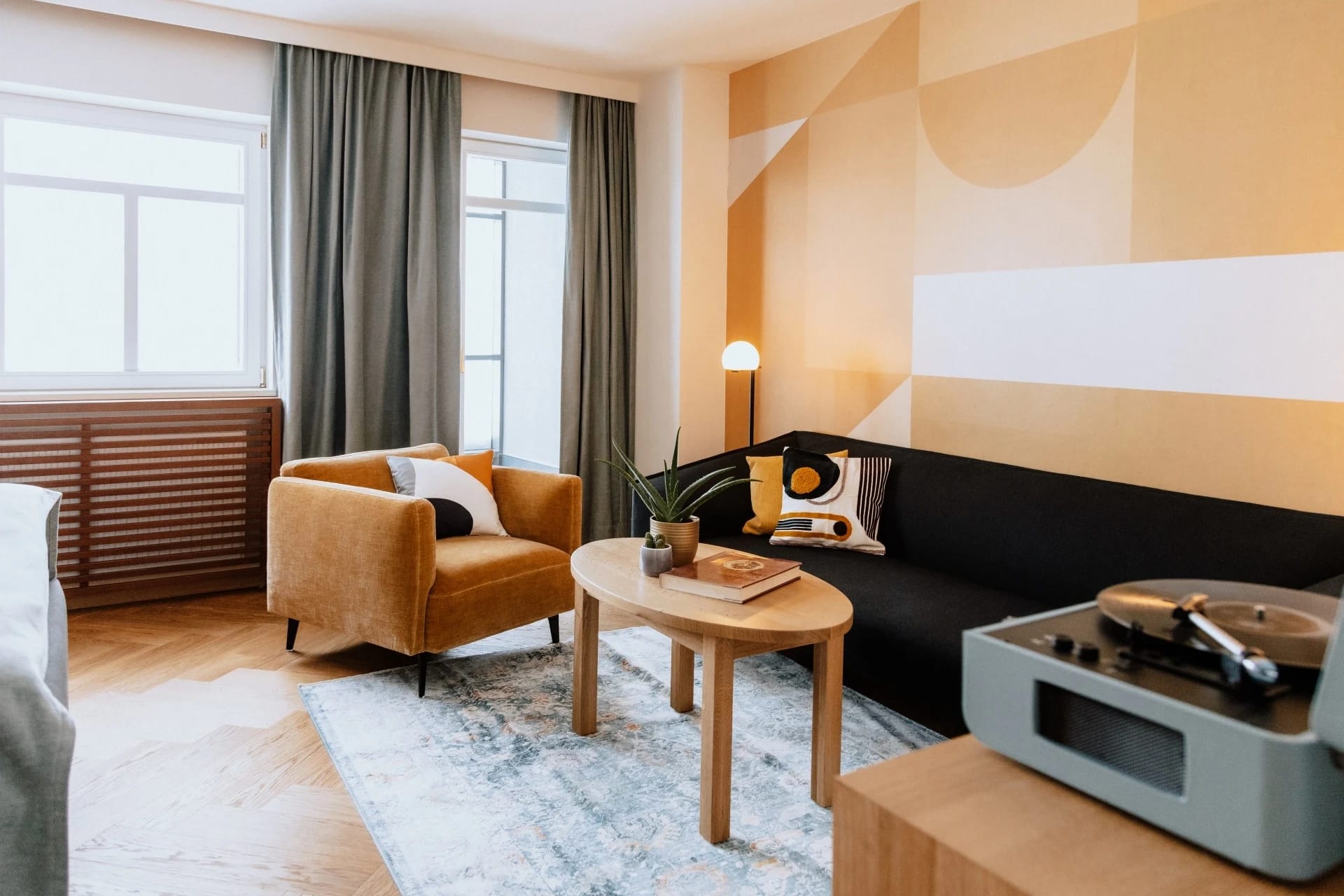 Wohnzimmer der Seinerzeit Suite mit orangefarbenen Sesseln und Retro-Plattenspieler