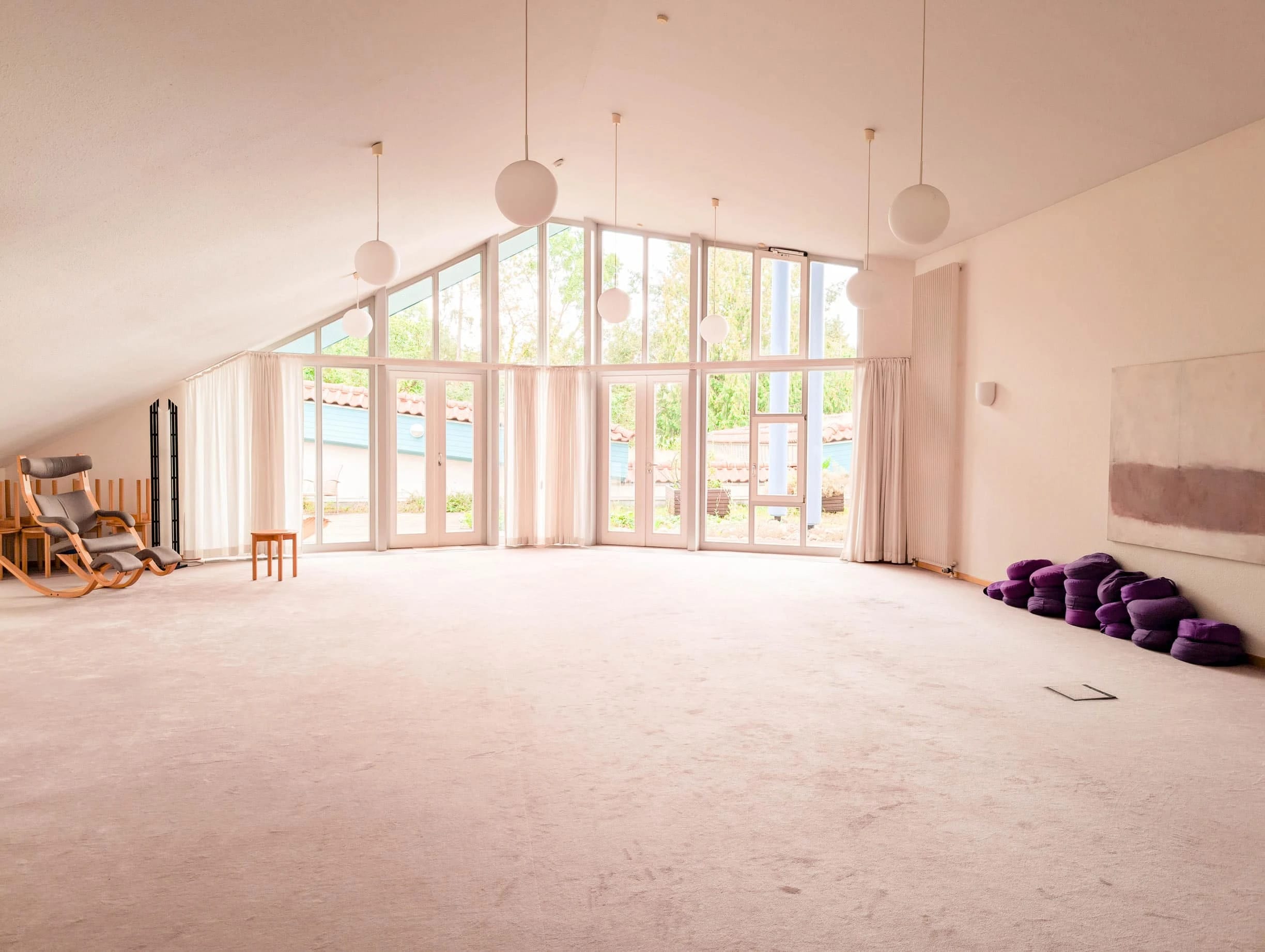 Meditationsraum mit großer Fensterfront und Sitzkissen
