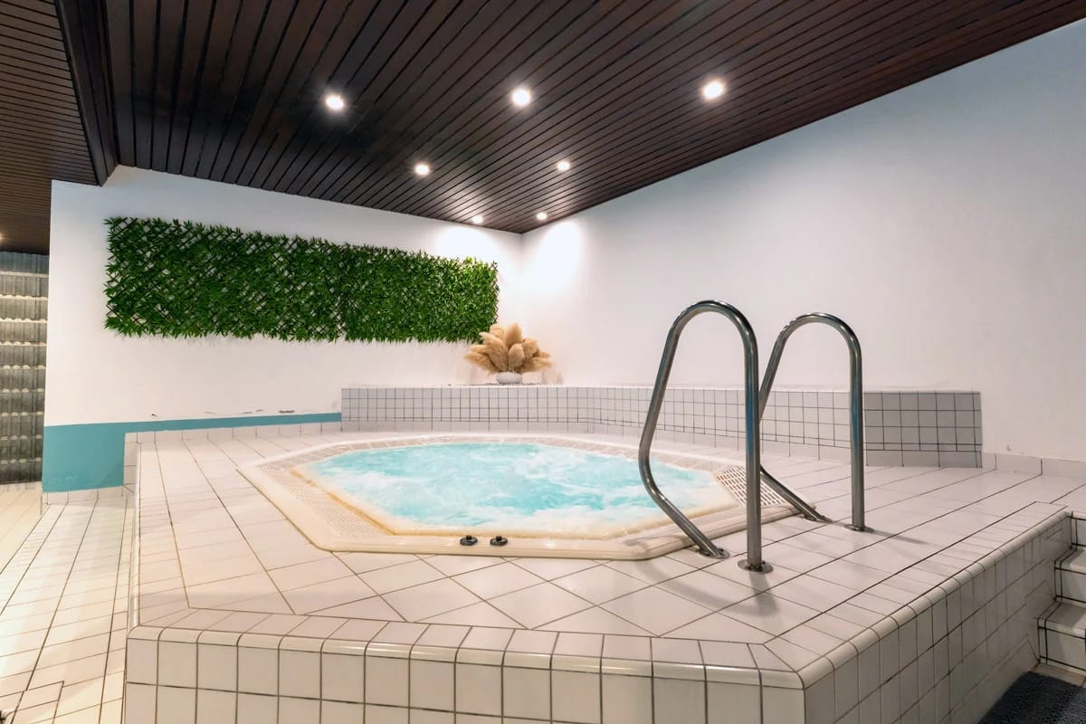 Whirlpool im gefliesten Wellnessbereich mit begrünter Wand