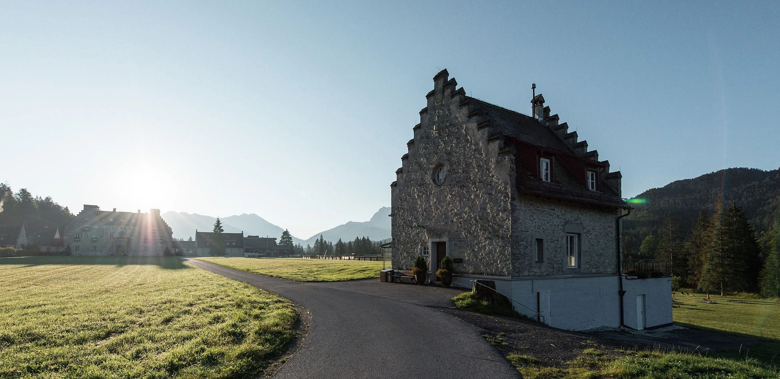 Steinernes Torhaus mit Staffelgiebel am Wiesenweg in der tief stehenden Morgensonne