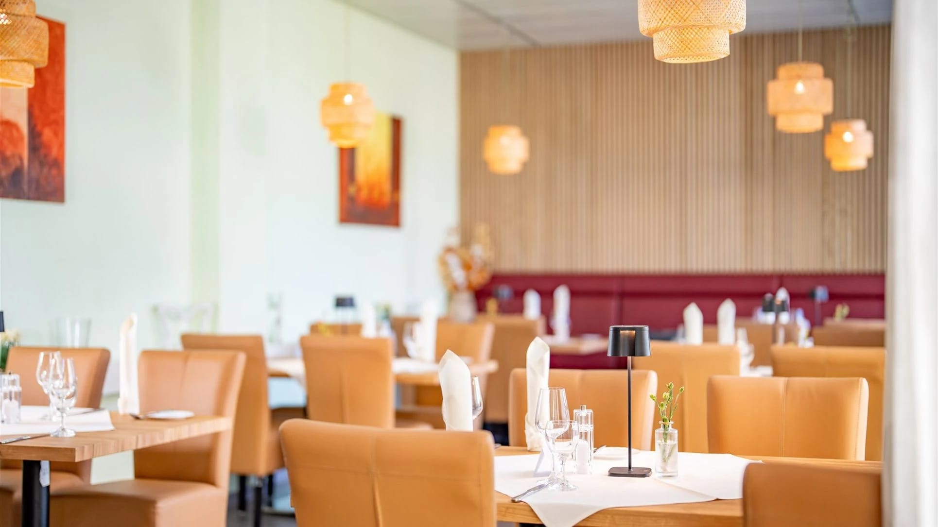 Restaurant mit eingedeckten Tischen und Hängeleuchten