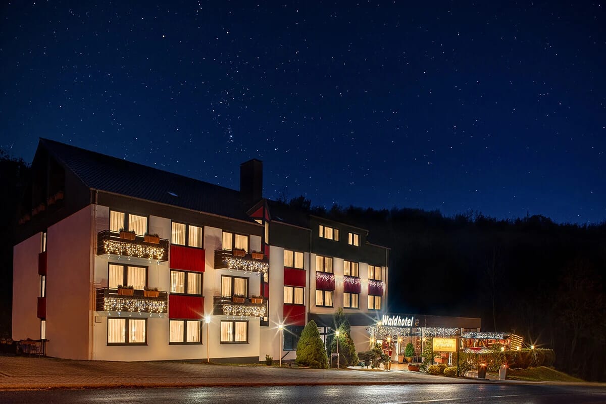 Beleuchtetes Hotelgebäude bei Nacht unter Sternenhimmel