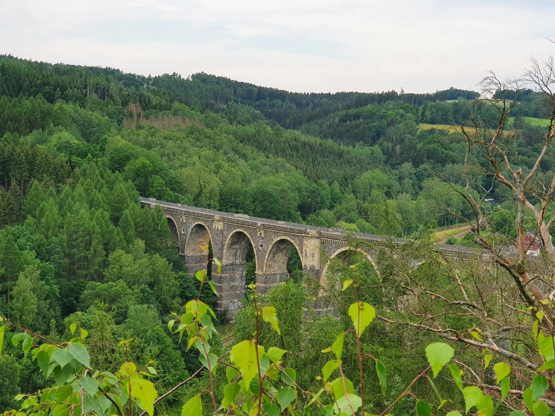 Alte Steinbogenbrücke über ein bewaldetes Tal