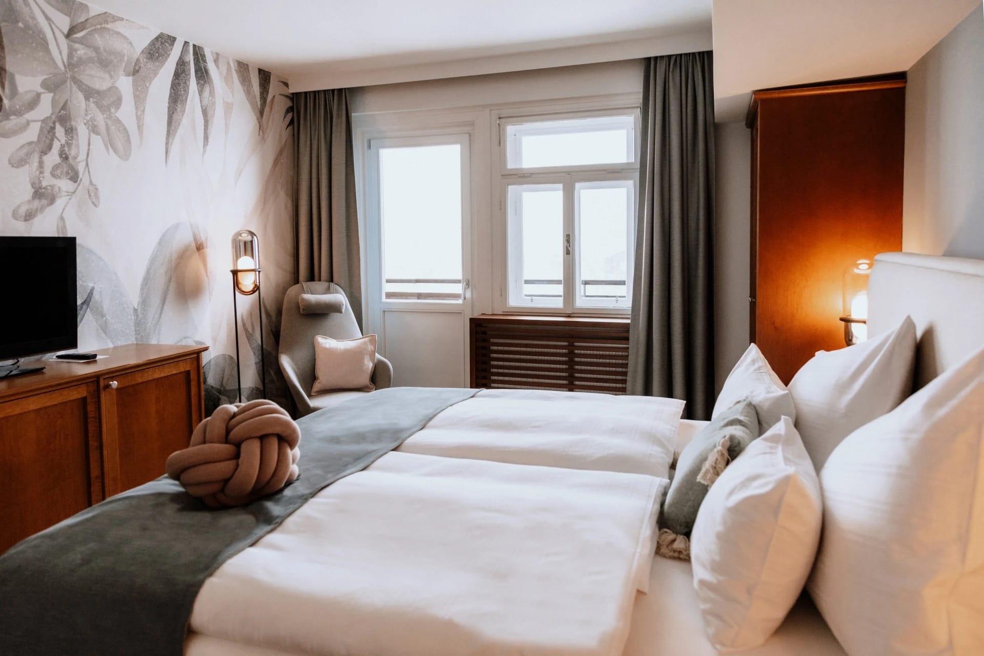 Schlafzimmer der Zeitlos Suite mit botanischer Tapete und Doppelbett