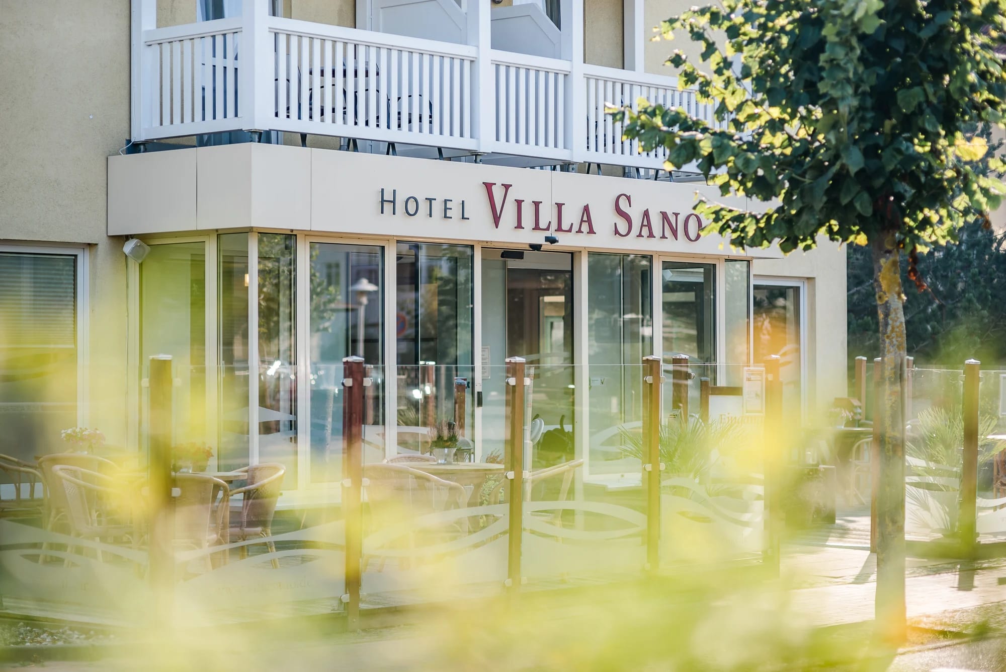 Eingangsbereich des Hotels Villa Sano mit Schriftzug und verglaster Front