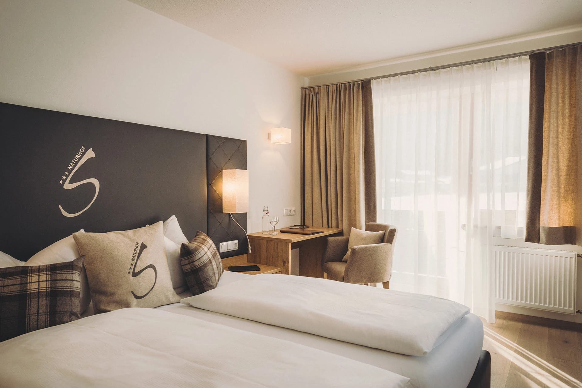 Helles Doppelzimmer mit Holzboden, Schreibtisch und bodentiefer Fenstertür