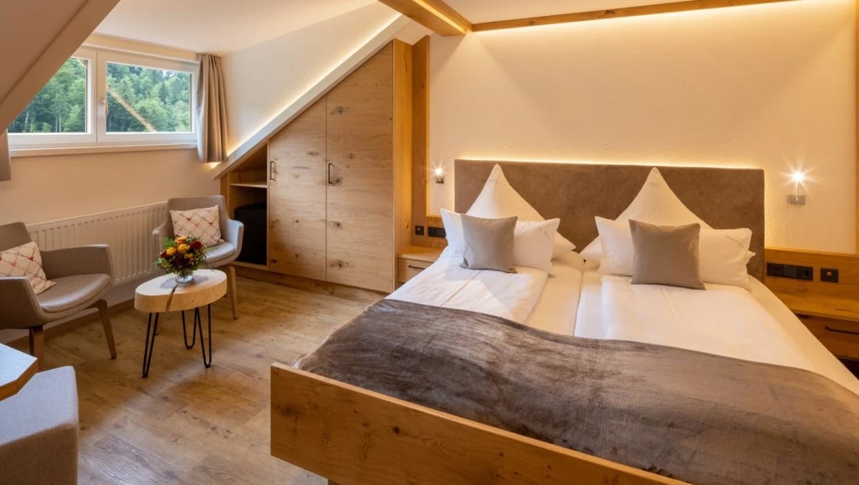 Doppelzimmer mit Sitzecke, Sesseln und Dachschräge