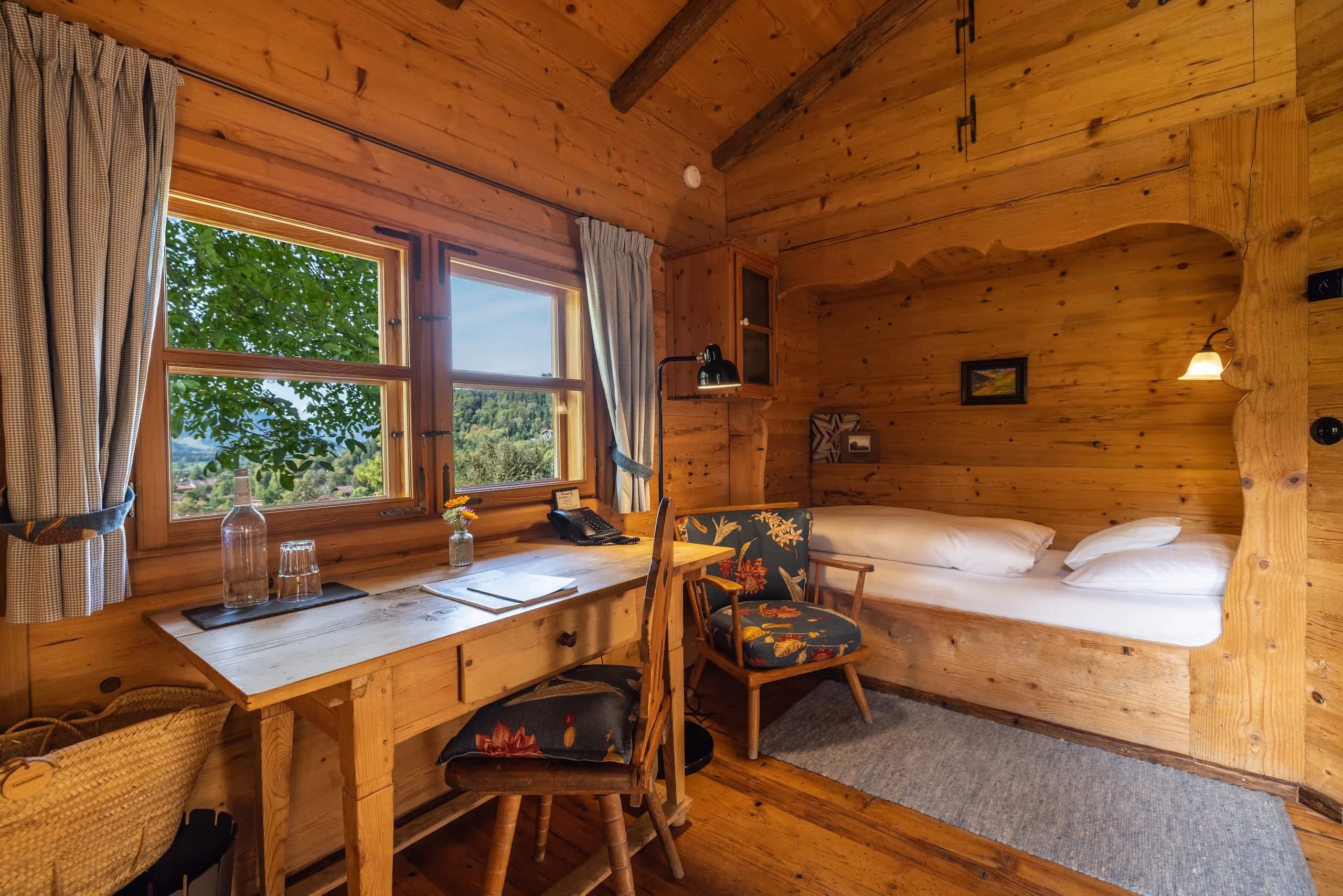 Rustikales Lufthütten-Zimmer mit Holzwänden, Bettnische, Schreibtisch und Bauernstuhl