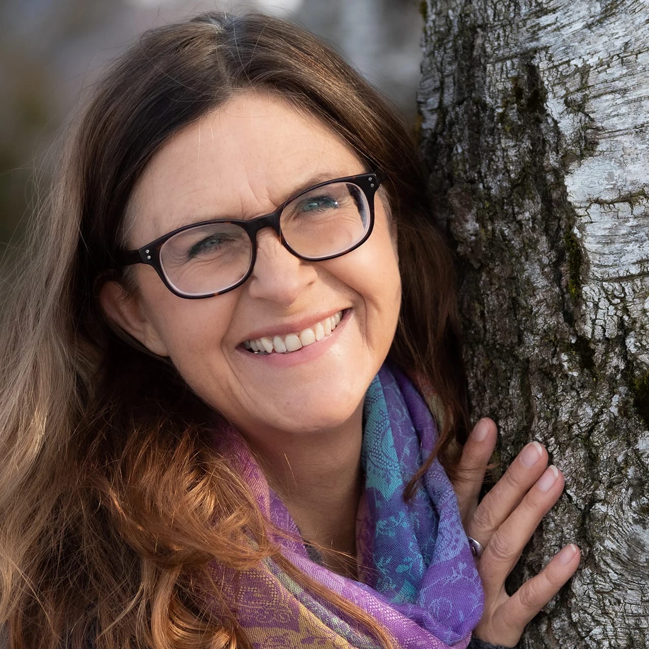 Porträt von Christine Fegerl, lächelnd mit Brille im Freien