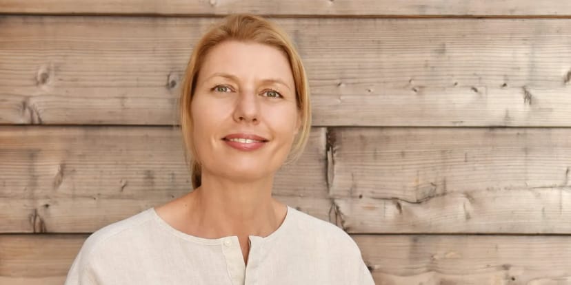 Porträt von Corinna Bucher vor einer hellen Holzwand