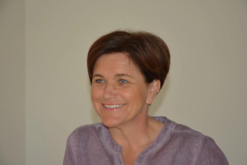 Porträt von Luise Eckhart-Wöllkart, lächelnd vor neutralem Hintergrund