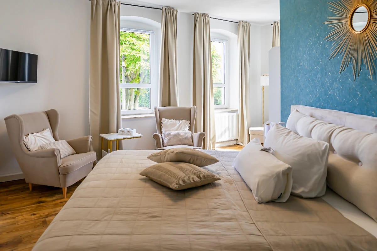 Doppelzimmer in Beige- und Türkistönen mit zwei Ohrensesseln