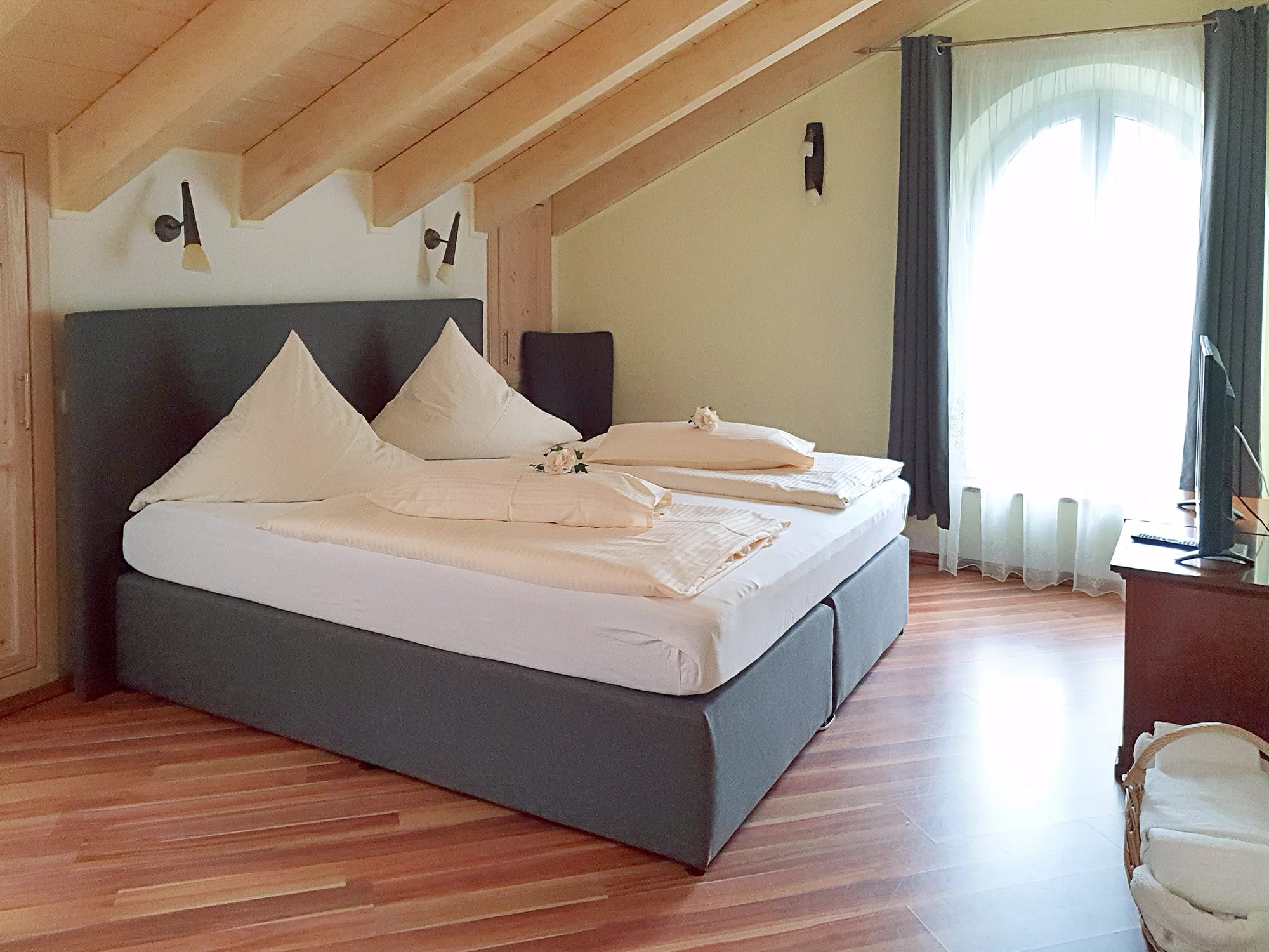 Doppelzimmer unter Dachschräge mit Doppelbett, Holzdecke und Fenster