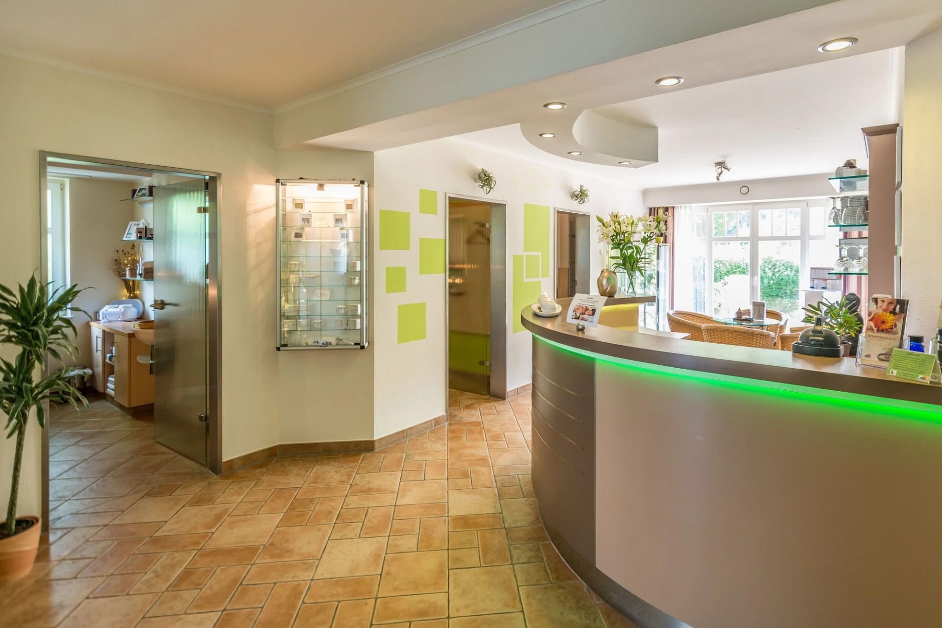 Empfangsbereich des Day Spa mit geschwungenem Tresen und grünen Akzenten