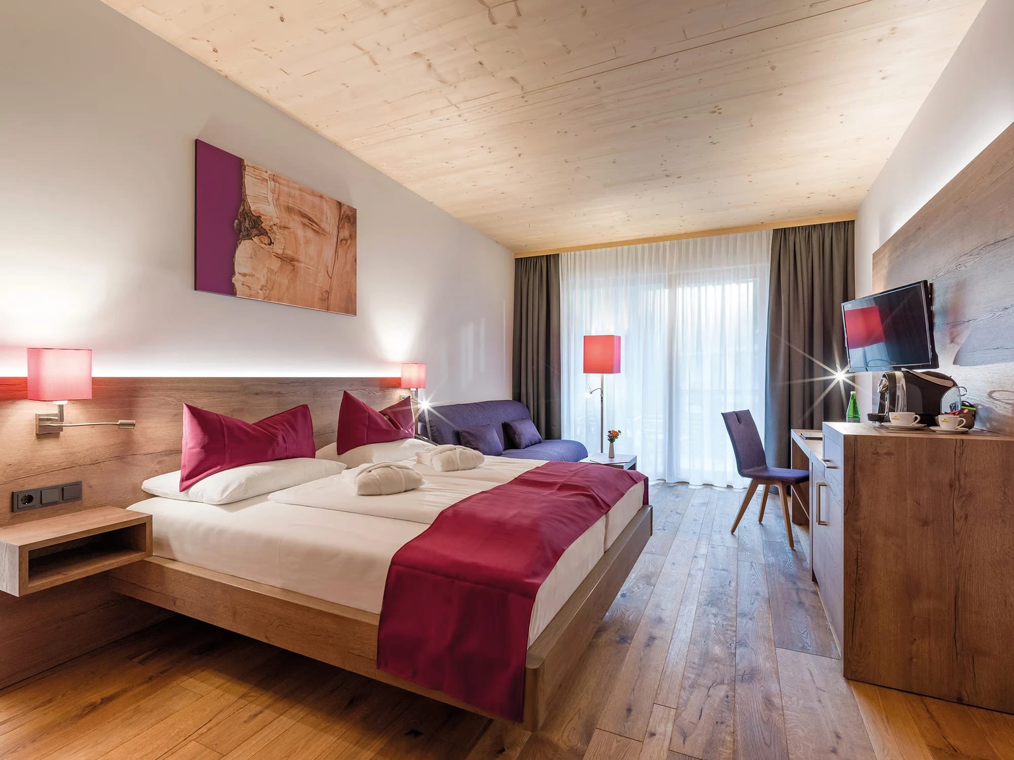 Helles Doppelzimmer mit Holzdecke, Holzboden und roséfarbenen Akzenten