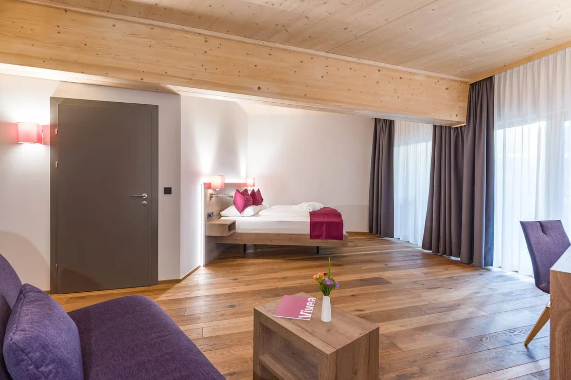 Geräumige Suite mit Bett, Sitzbereich und Holzboden