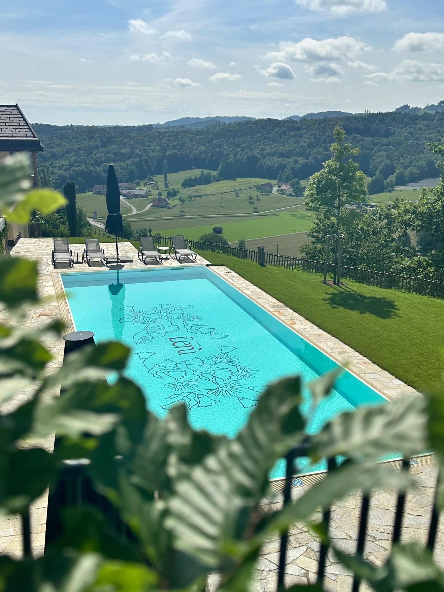 Pool mit Sonnenschirm und Panoramablick über die sanften Hügel