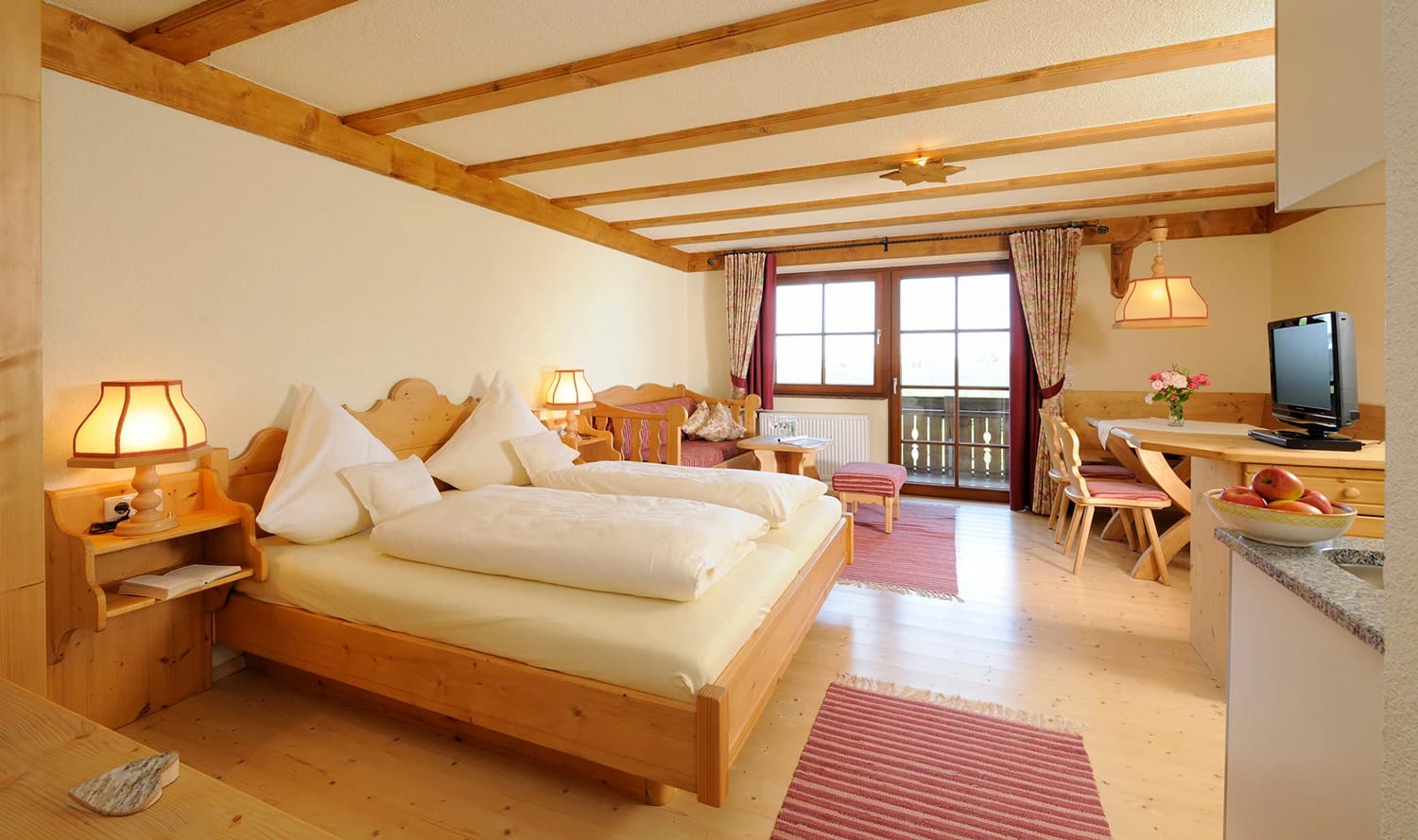 Geräumiges Zimmer mit Doppelbett, Holzdecke und Sitzecke
