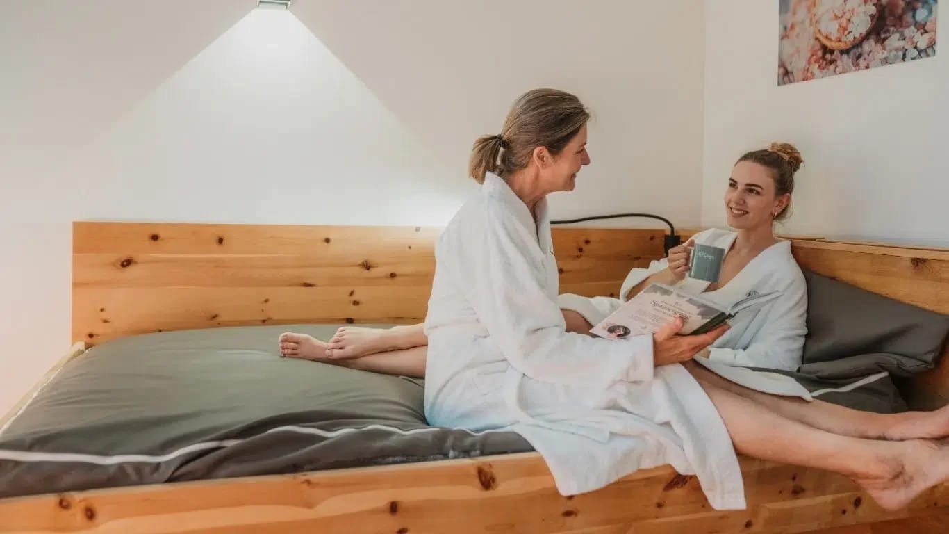 Hotelzimmer mit Zirbenholzbett und warmer, natürlicher Einrichtung