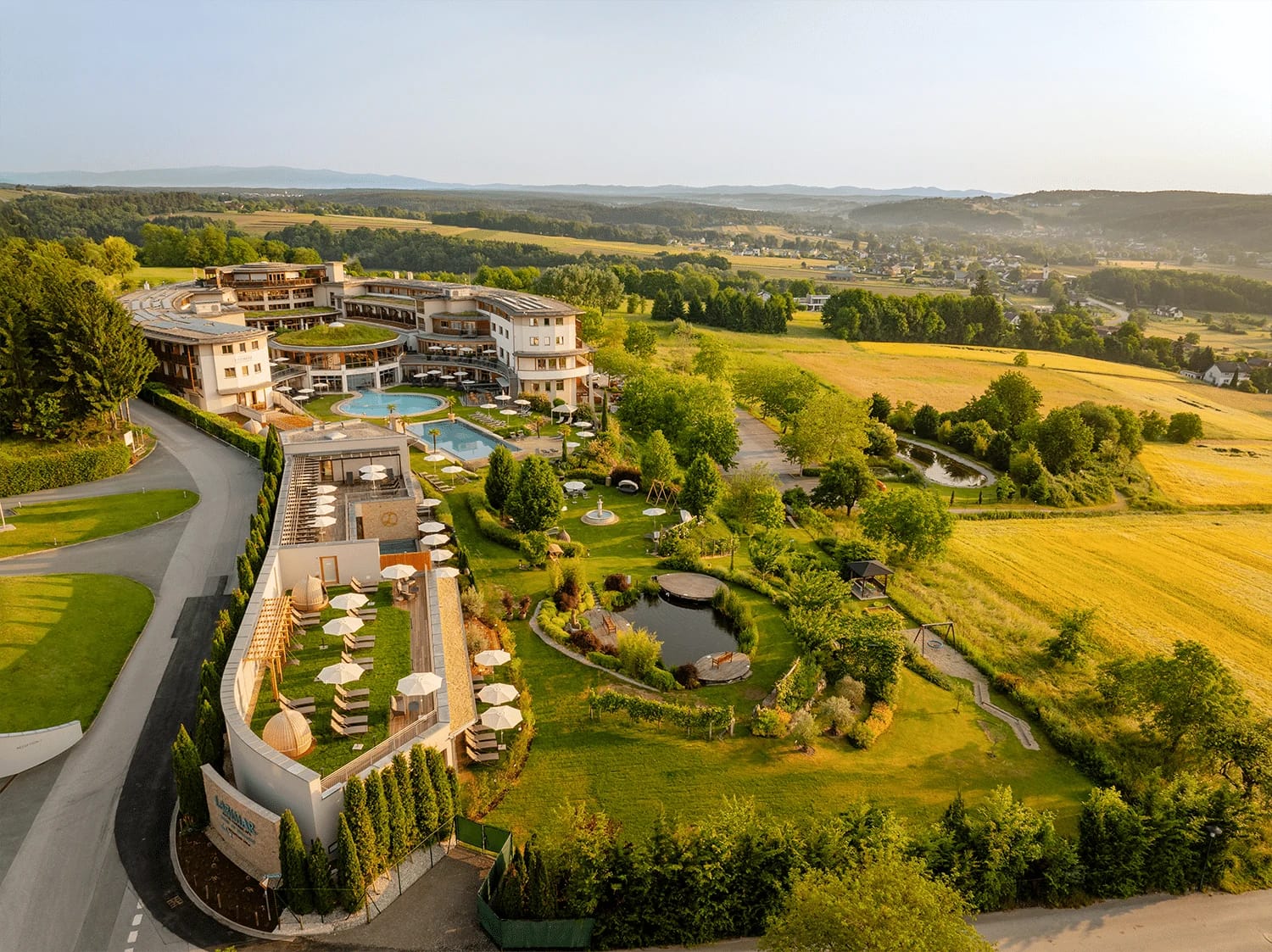 Luftaufnahme des Hotels mit weitläufigem Garten, Teichen und Pools