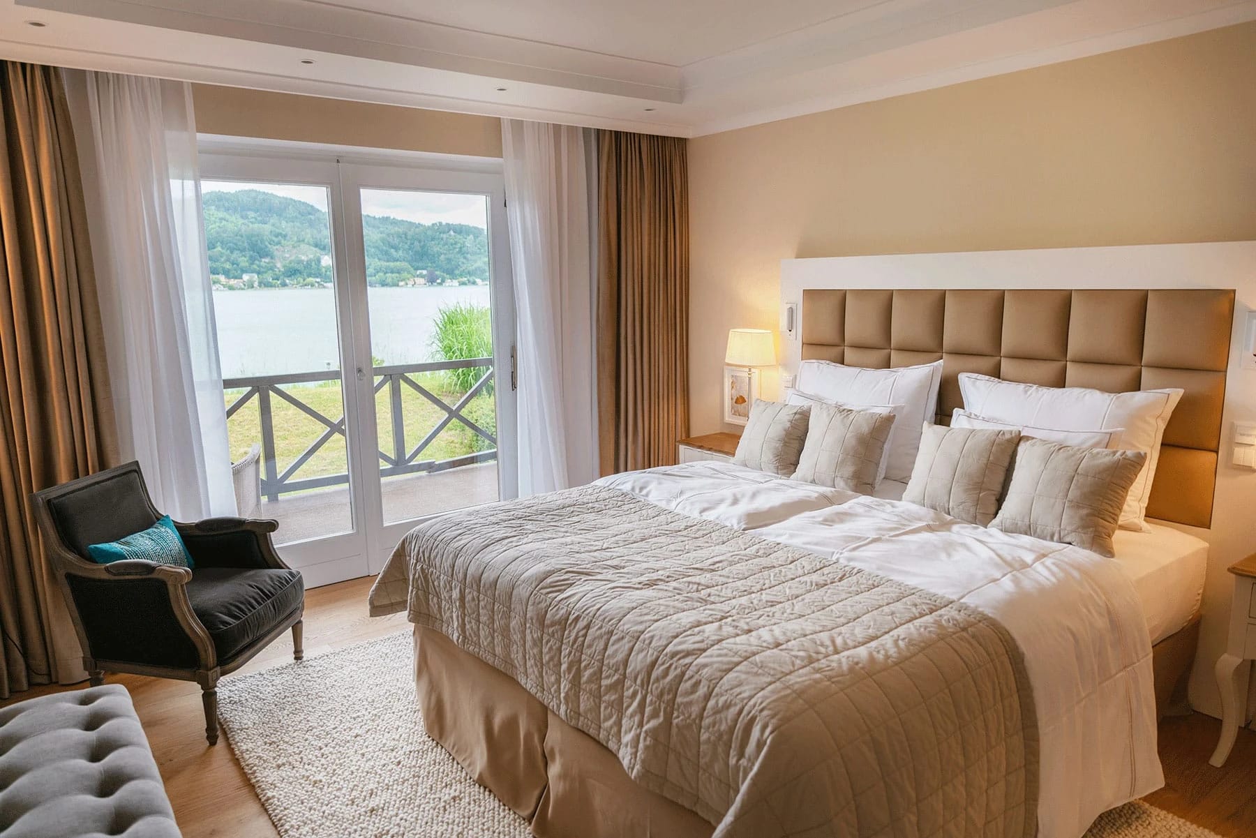 Schlafzimmer mit Doppelbett und Balkontür mit Blick auf den See