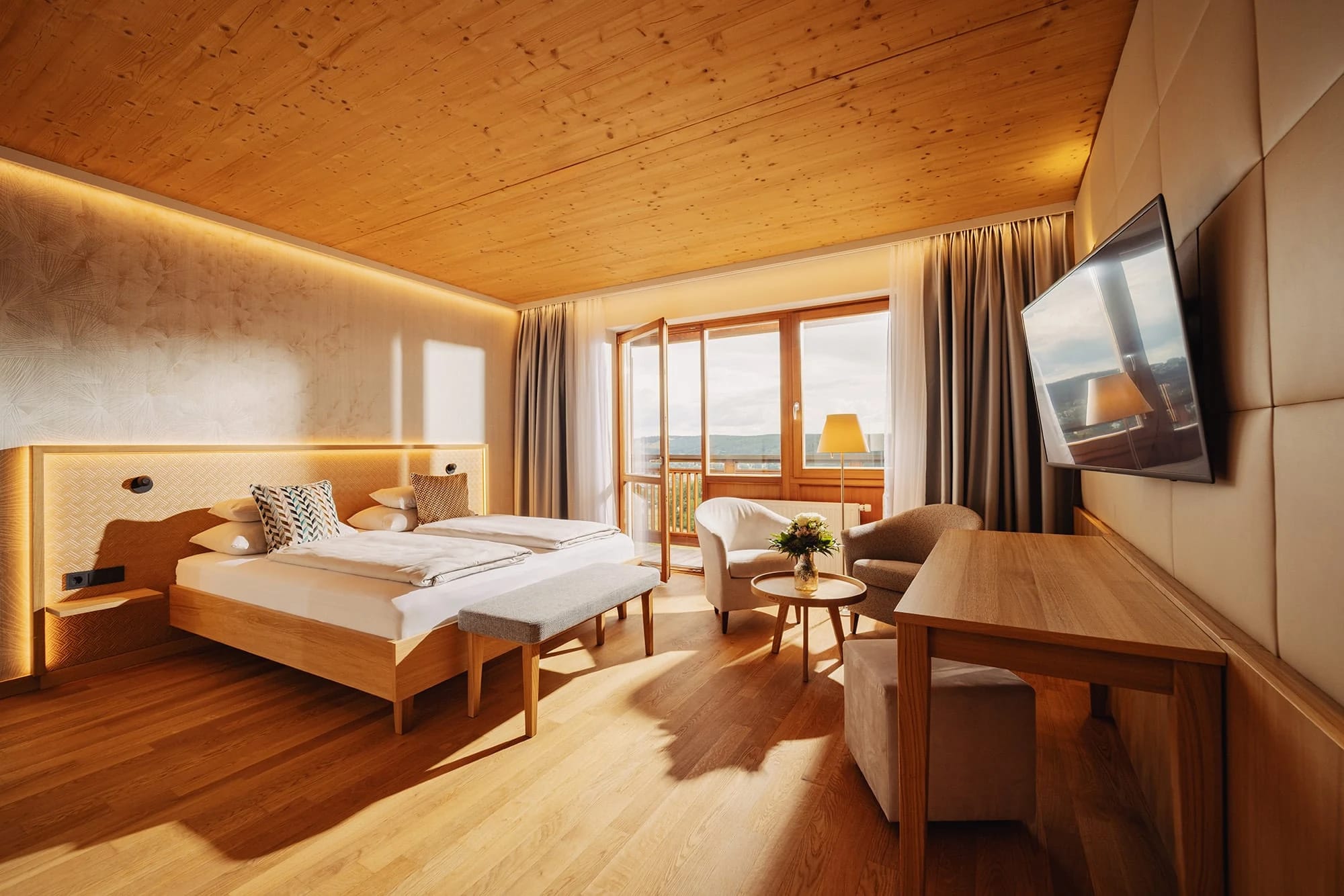 Zimmer mit Doppelbett, Holzdecke und Balkon mit Ausblick