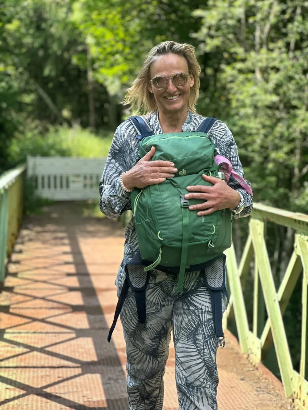 Porträt von Ute Hesse mit Rucksack auf einer Brücke im Wald