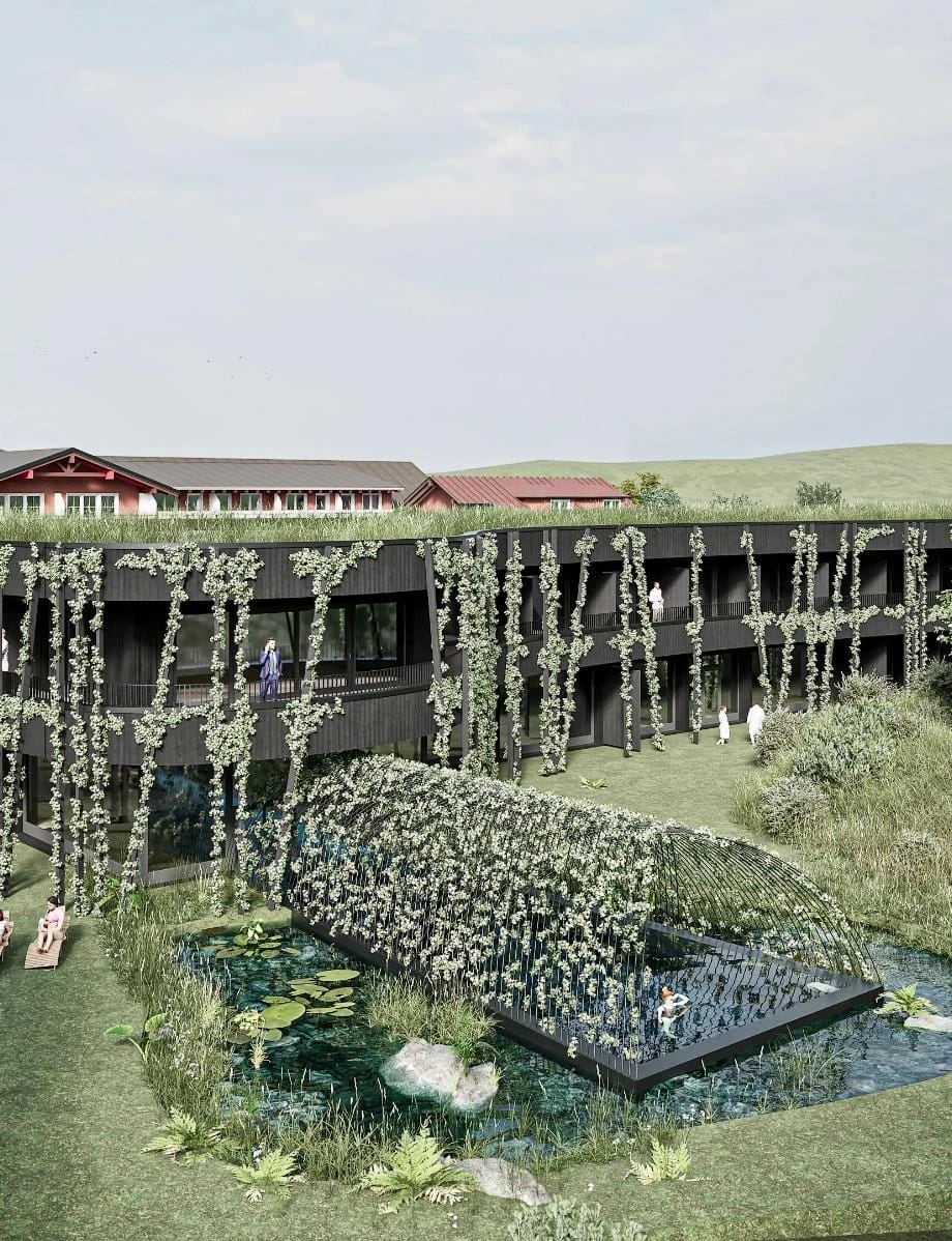 Begrünte Naturfassade des Hotels mit Rankpflanzen und Teich davor